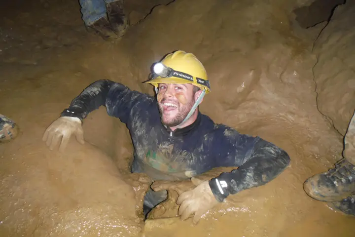 Smiling man coming out of cavern