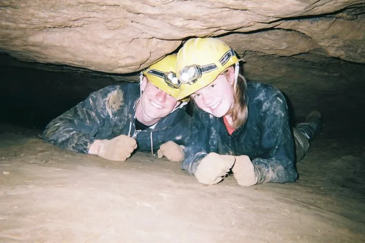 Couple crawling in cave